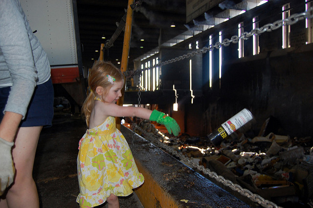 Tossing empty spray cans into the abyss in her finest summer attire at the South Seattle Transfer Station