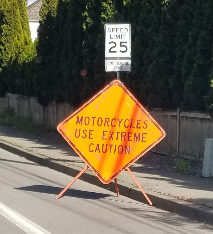 motorcycles use caution, road work sign,