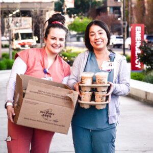 two MultiCare Auburn Medical Center nurses accept coffee and snacks donated by Big Foot Jav