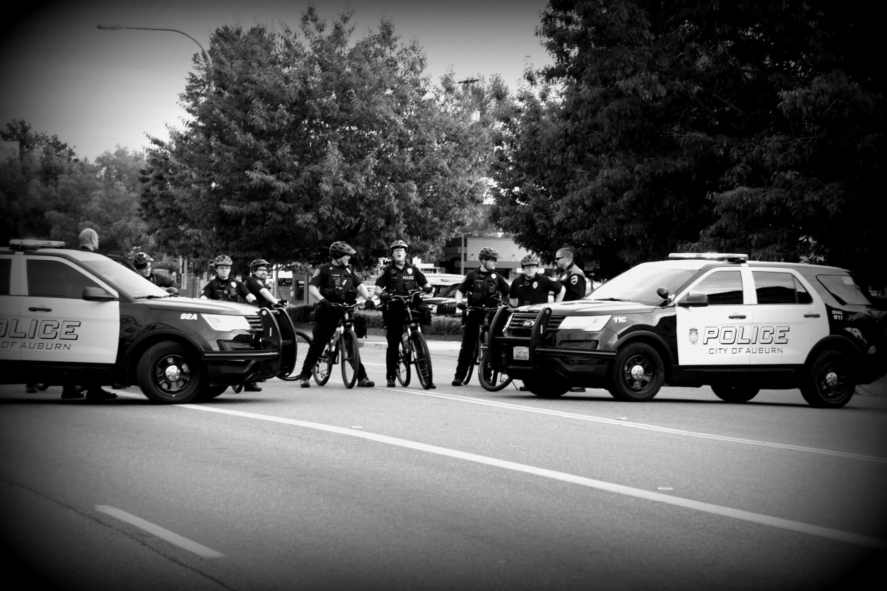 APD cruisers and bike cops stretch across a road