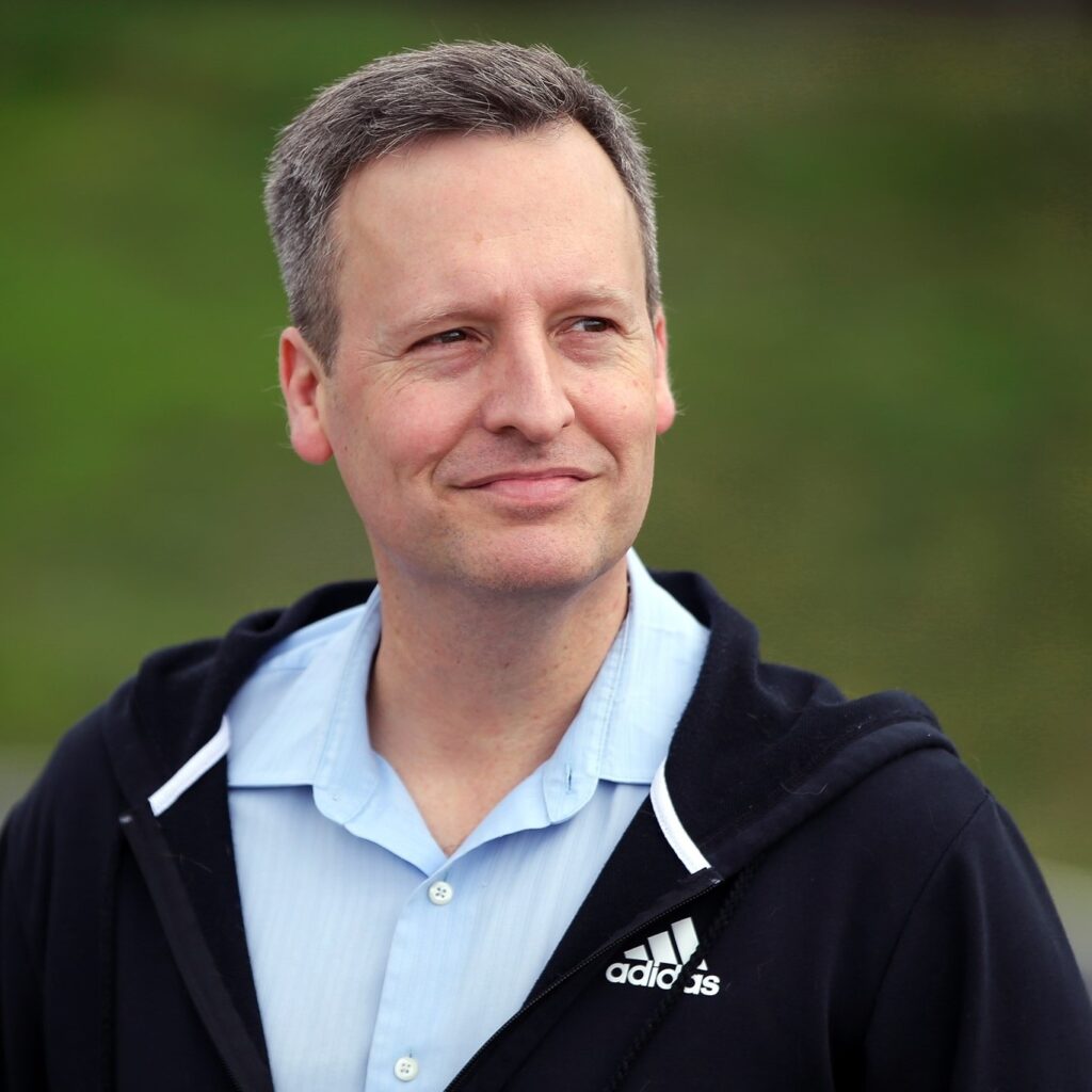 Photo of King County Councilmember Dave Upthegrove wearing a dark navy adidas hoodie and light blue button up shirt.