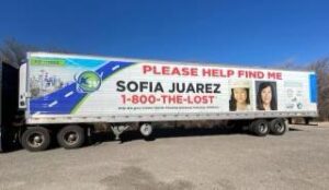 A tractor trailer with lettering and photos stating "Please help find me" "Sofia Juarez" and "1 800 the lost"