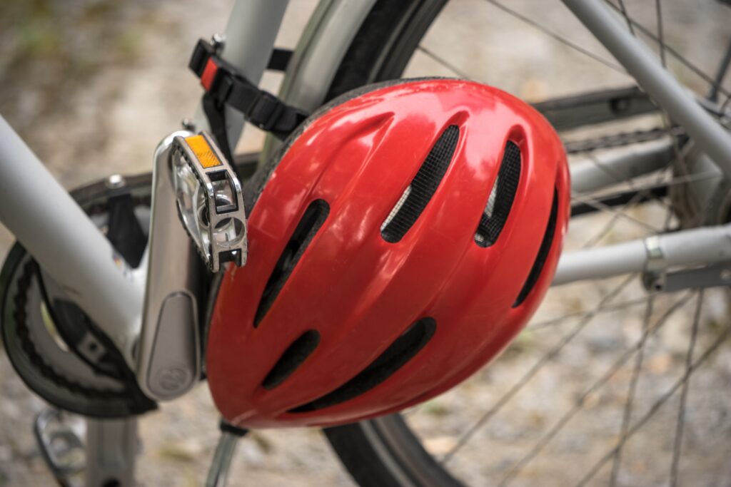 A red bike helmet is buckled around the middle of the bike.
