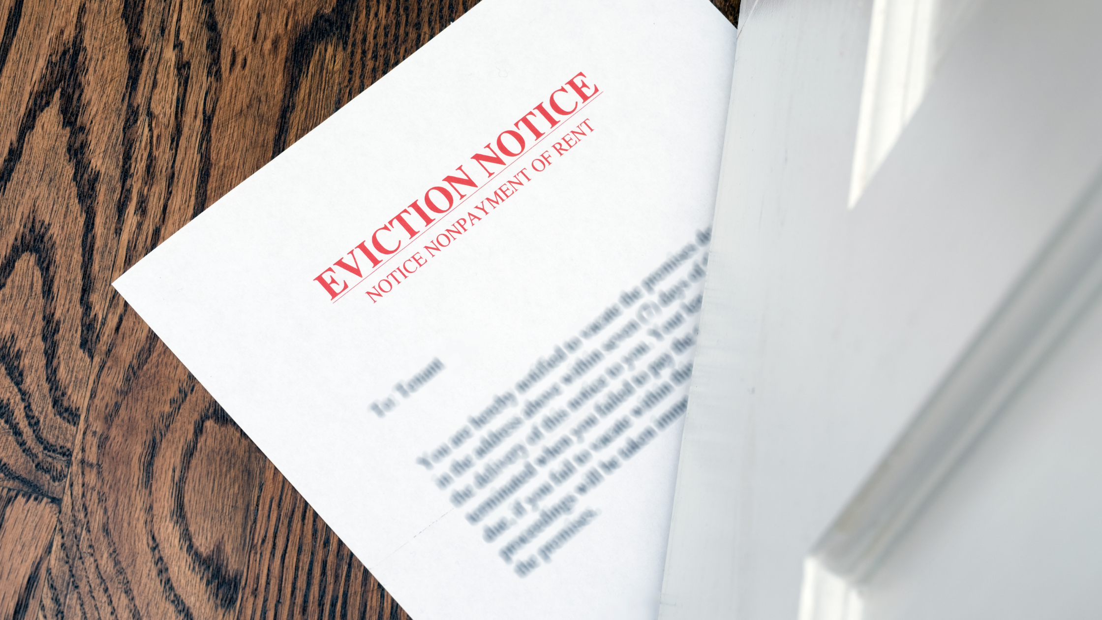 an eviction notice is slid under a white door