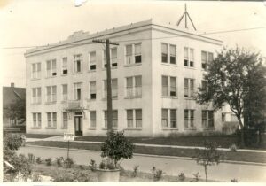 A historic photo of a square building, the Taylor-Lacey Hospital circa 1921