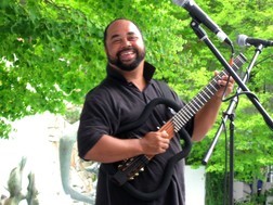 Jazz Guitar player Michael Powers smiles at the camera while performing with his guitar
