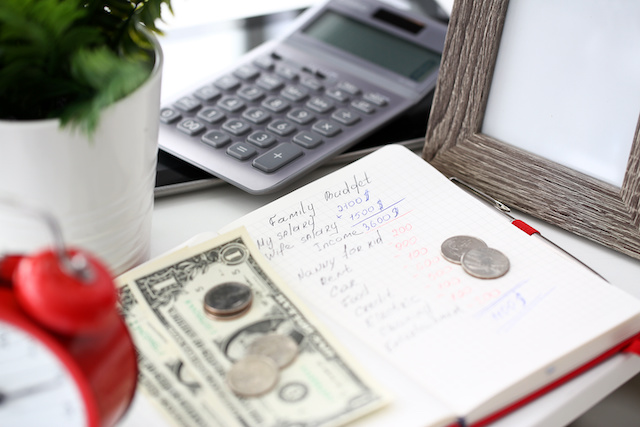 Notepad with handwritten calculations of family budget closeup