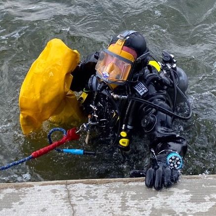 A diver comes out of the water at the dock