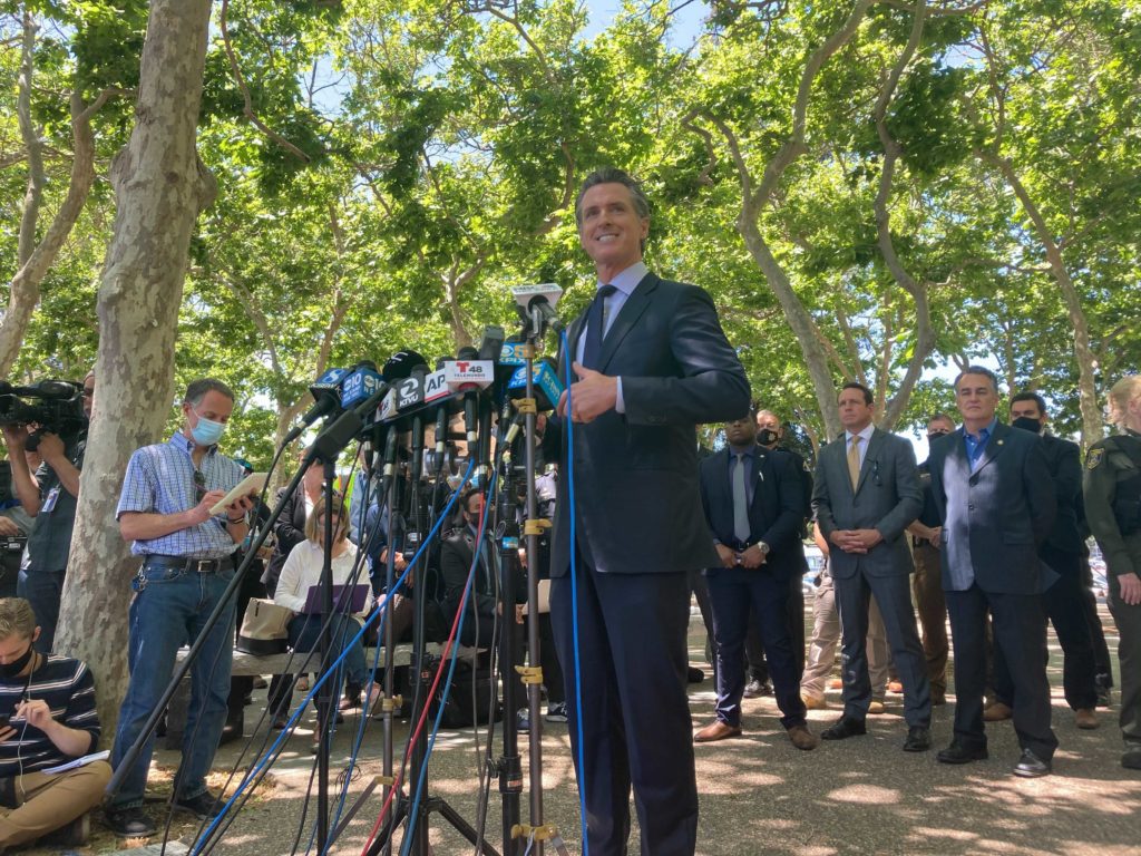 Gov. Gavin Newsom speaks at a stand of media microphones, speaking about the mass shooting at a VTA rail yard in San Jose. 