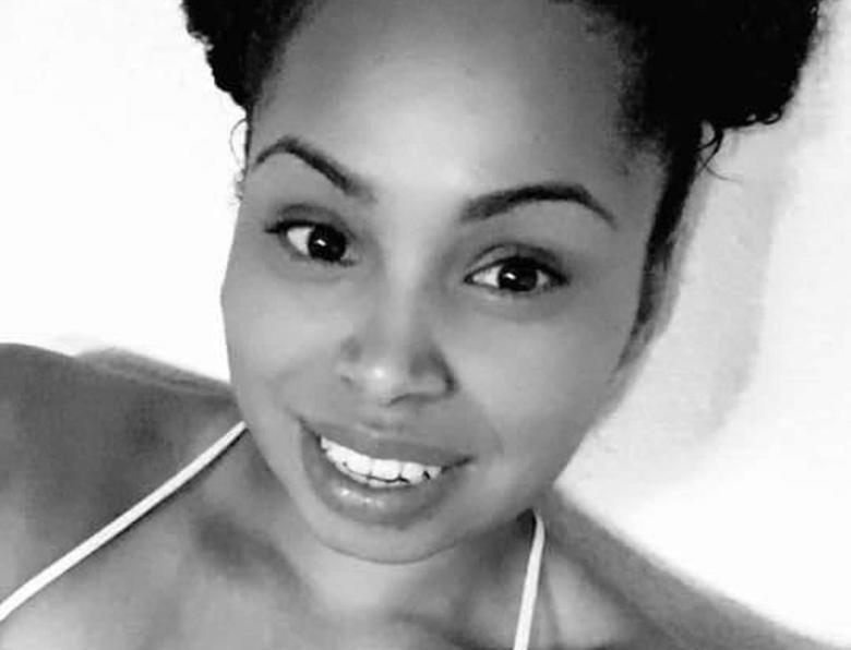 a black and white photo of Renee Davis smiling up at the camera