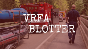 A VRFA aid car and swift water rescue boat is parked on a bridge. A V RFA crew member is walking away from the camera's perspective.