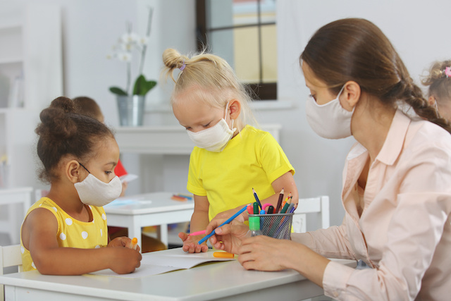 Teacher and children with face mask at school covid19 lesson after quarantine and lockdown
