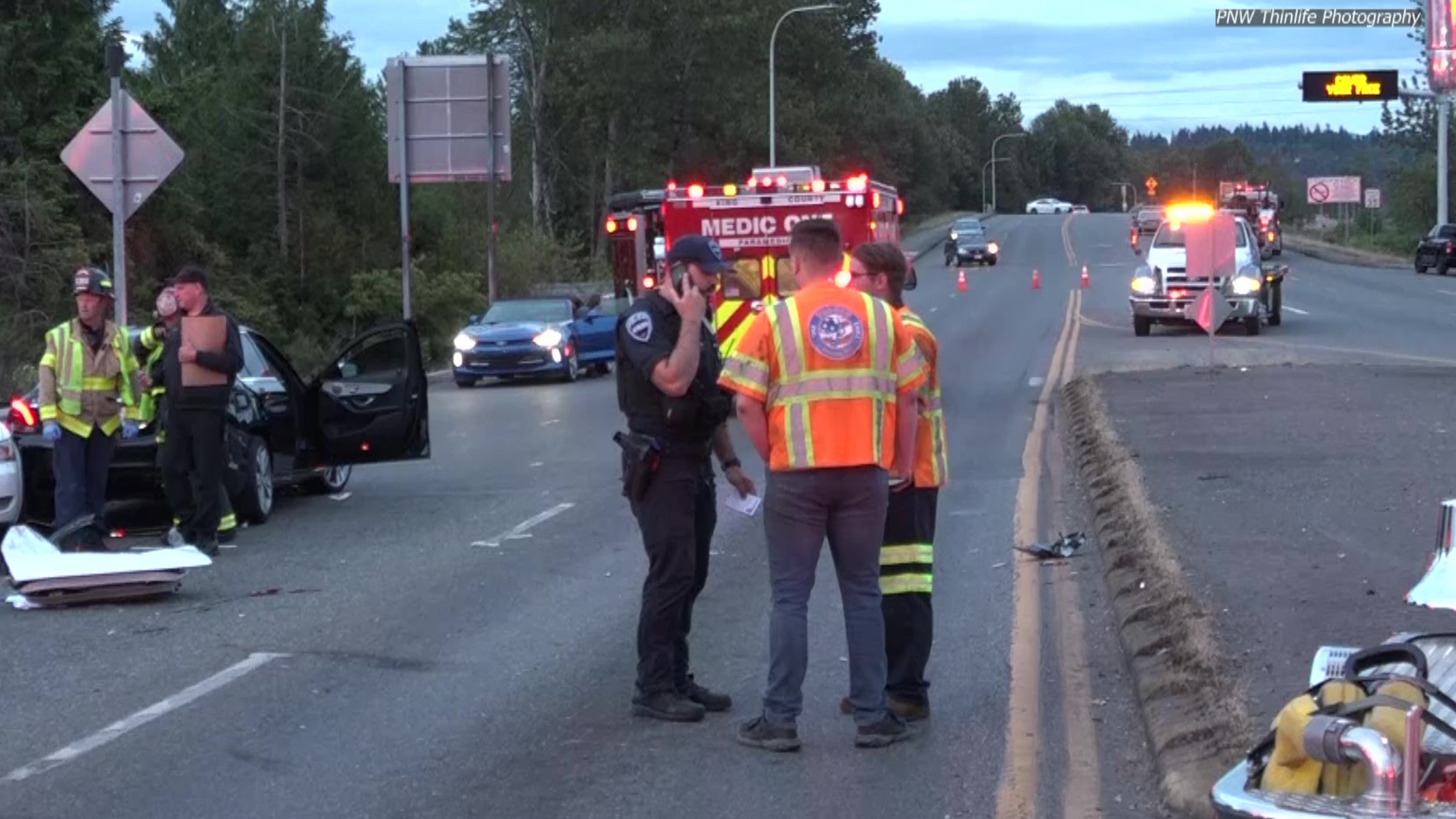 Police and medics talk in a huddle on scene of a motorvehicle accident