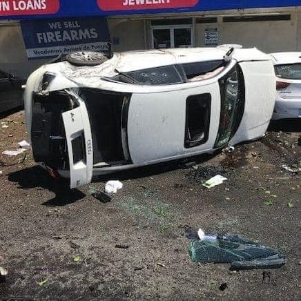 A white sedan rests on its side after a roll over Collison