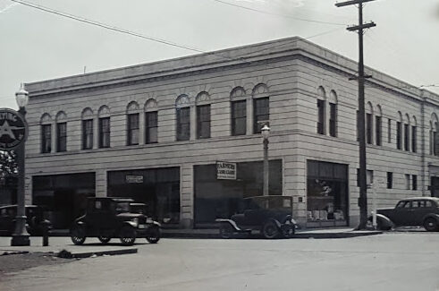 1930s Street Scene, showing the Masonic Temple and signage for Farmer’s Cash and Carry Store and Blanche’s Beauty Shop.