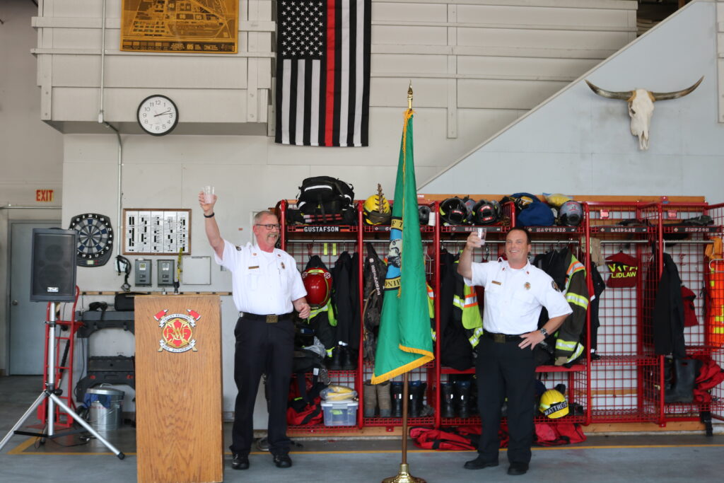 Retired VRFA Chief Brent Swearingen and new VRFA Chief Brad Thompson both raise a glass in a toast during the changing of the command ceremony