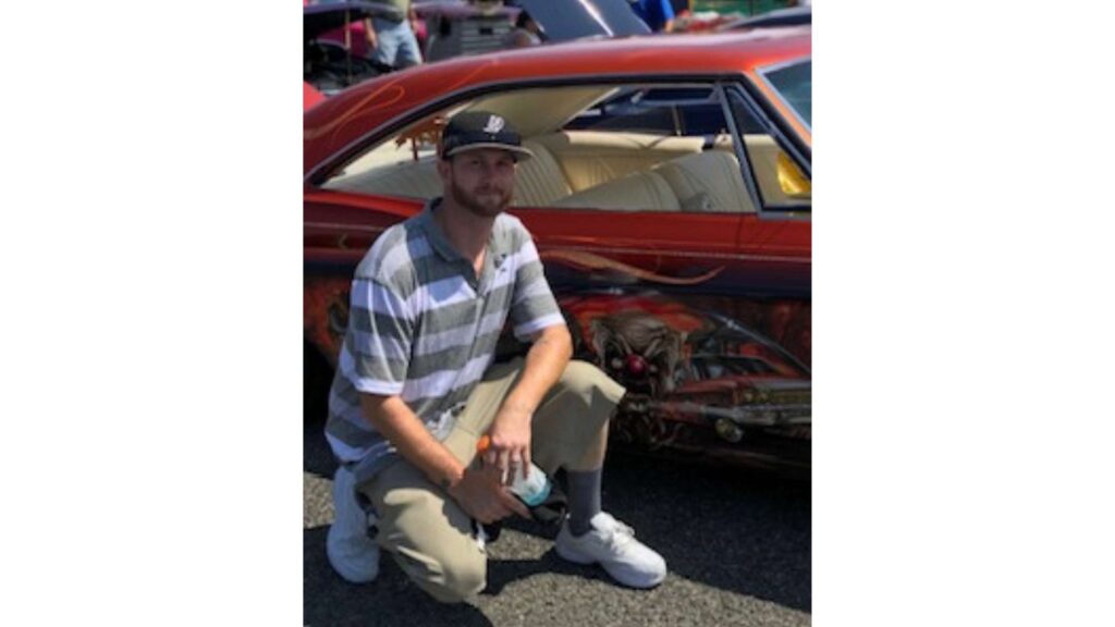 Photo of Ryan McCaughan in front of a red car