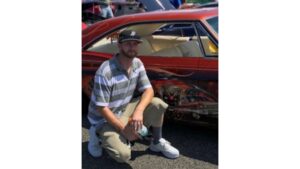 Photo of Ryan McCaughan in front of a red car