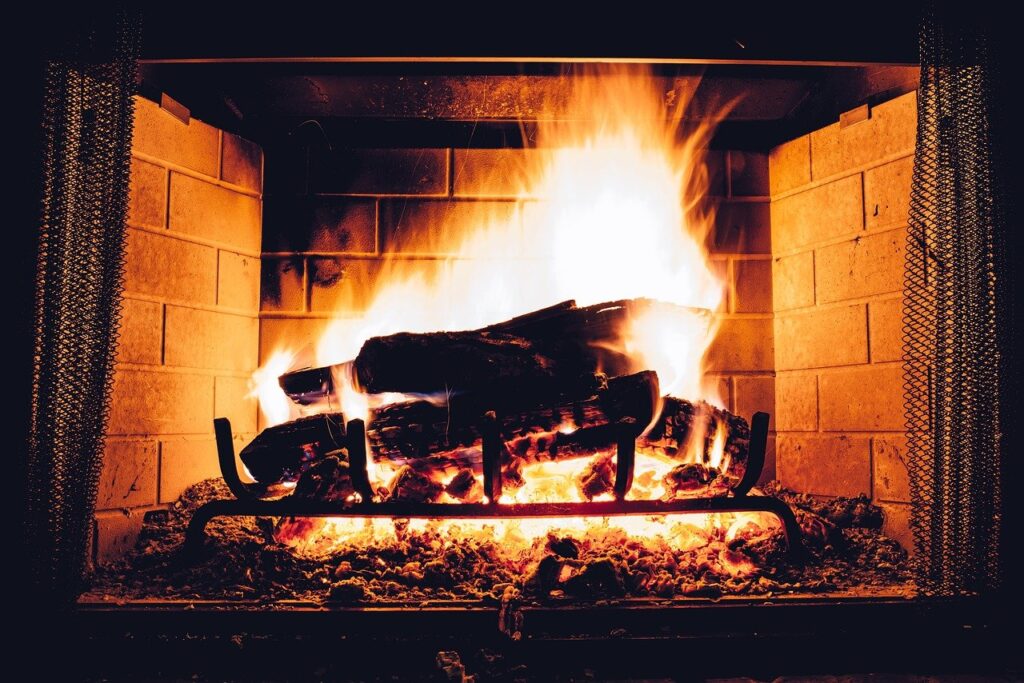 a wood burning fire burns in a fireplace