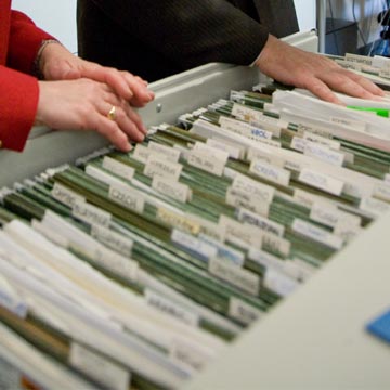 two people look through a large open file drawer