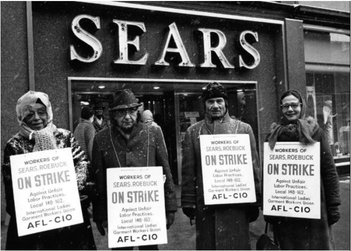An old photo of a group of male employees in winter coats and striking outside of Sears