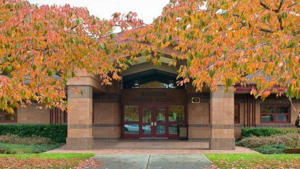 two trees with autumn leaves flank the brick front entrance of rainier middle school