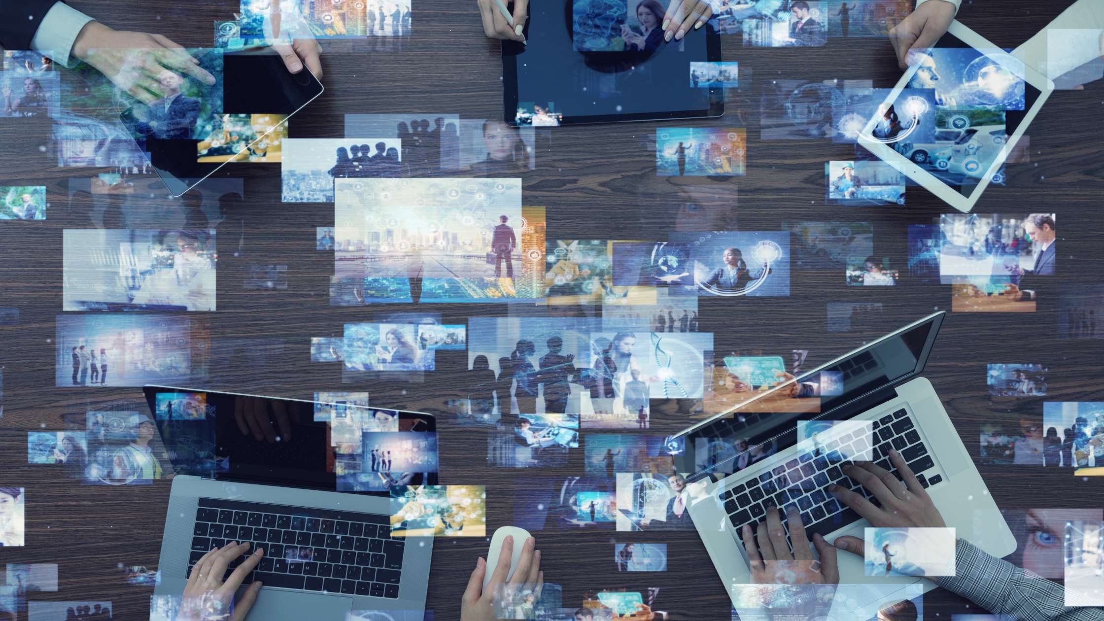 multiple videos show on screens, overlaying tablets and laptops on a table