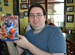 A white male holds up a book