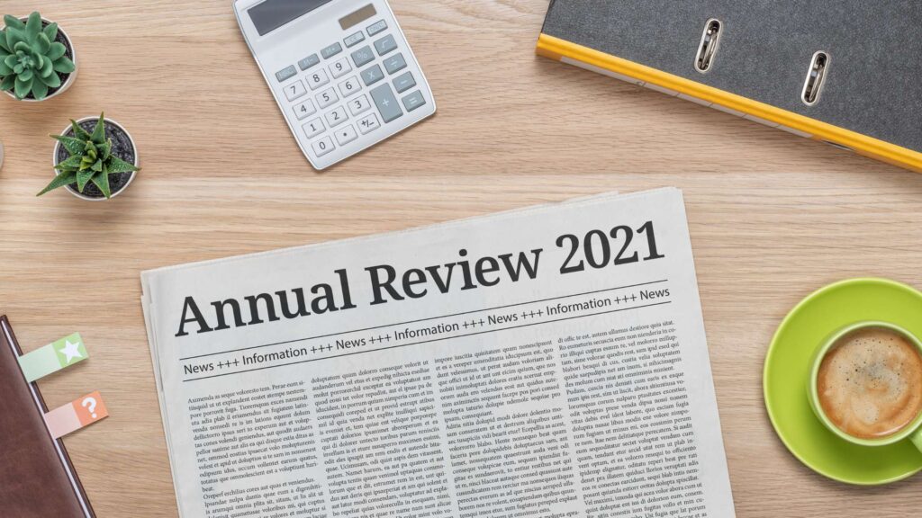 A newspaper lays on a desk with the headline "Annual Review 2021"