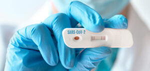 Doctor shows rapid laboratory COVID-19 test for detection of IgM and IgG antibodies to Novel Coronavirus, SARS-CoV-2 with positive result. Immunity against Covid-19, panoramic banner image.