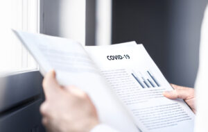 Coronavirus report about patient information or covid 19 impact on business finance market. Doctor reading virology laboratory research and test result. Medical record, death data or economy graph.