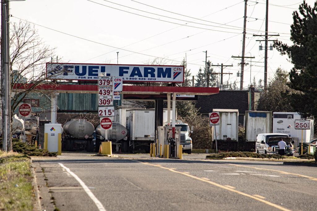 Looking down a three lane road at gas station 'Fuel Farm' in Auburn