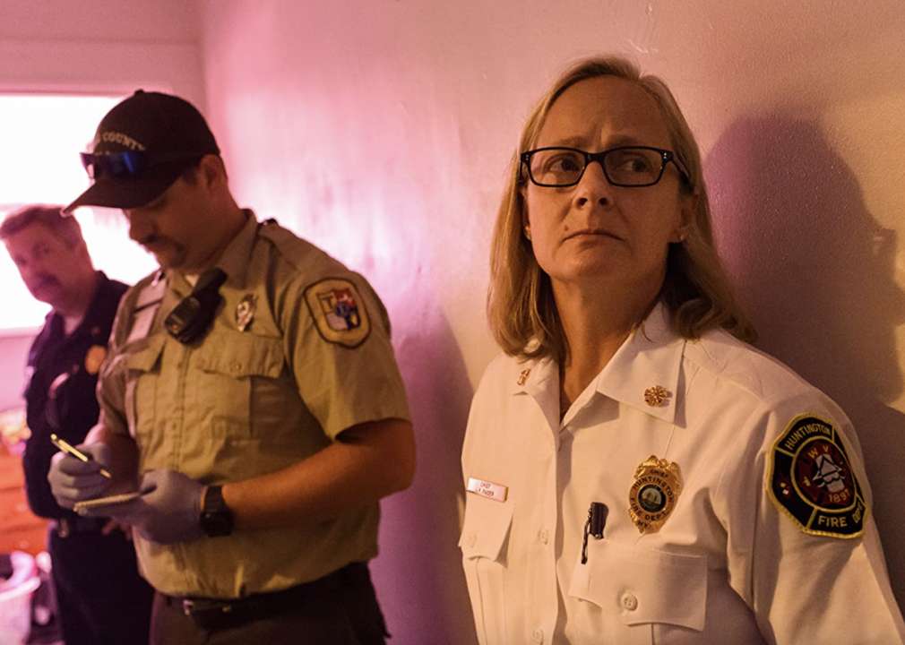 A female and male officer listen and take notes while on scene of an opioid related call