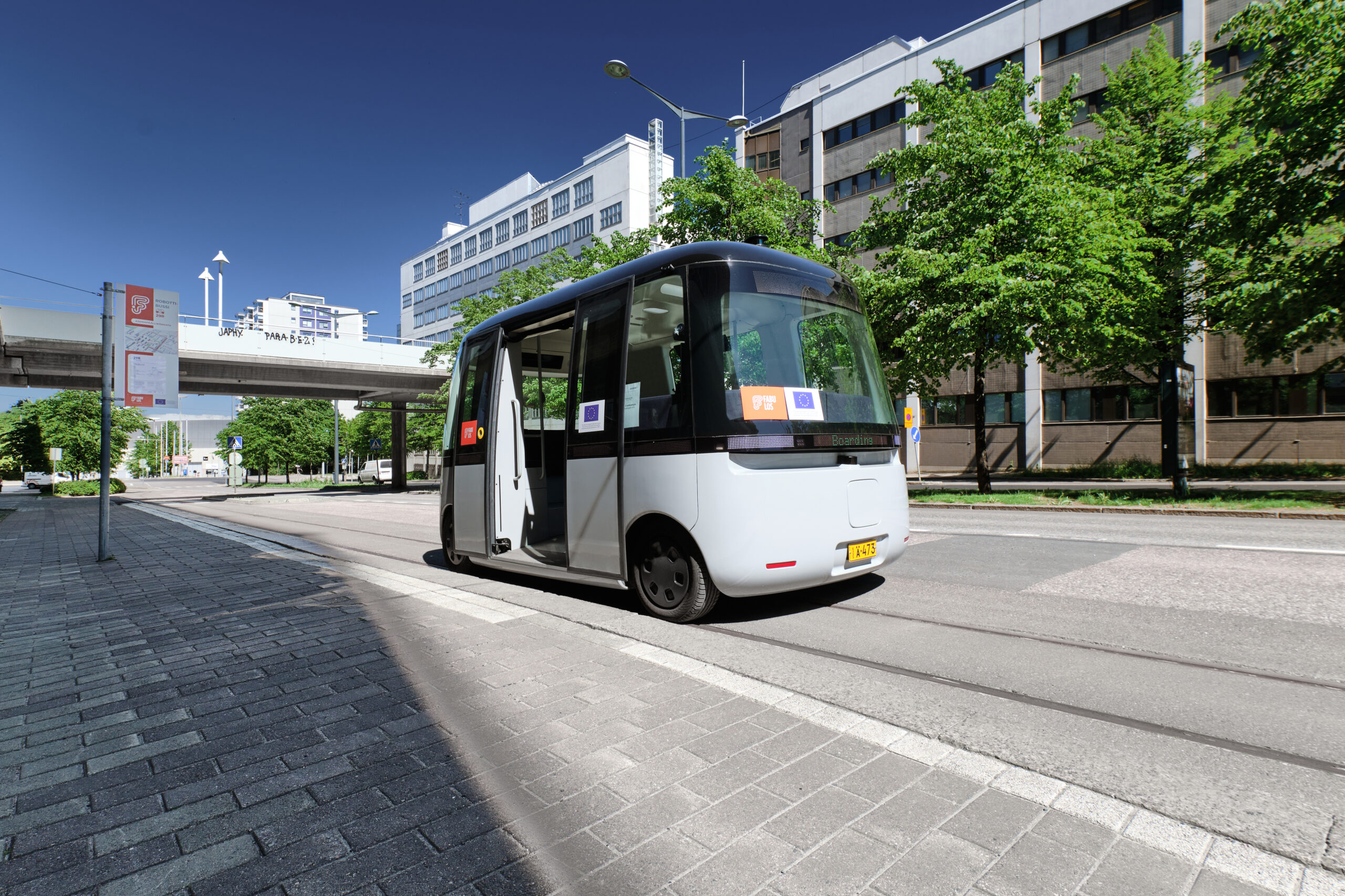 A square driverless vehicle is parked on a city street.