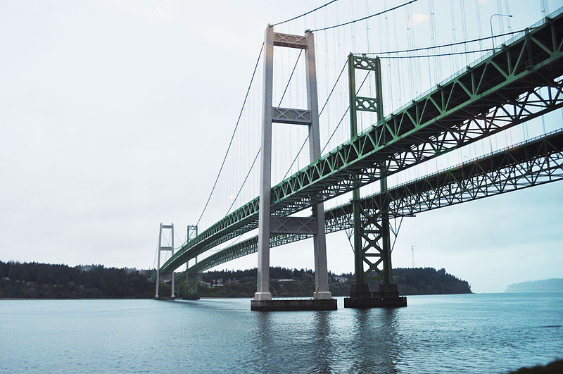 The Tacoma Narrows Bridge stretching over water, photo taken from below the bridge