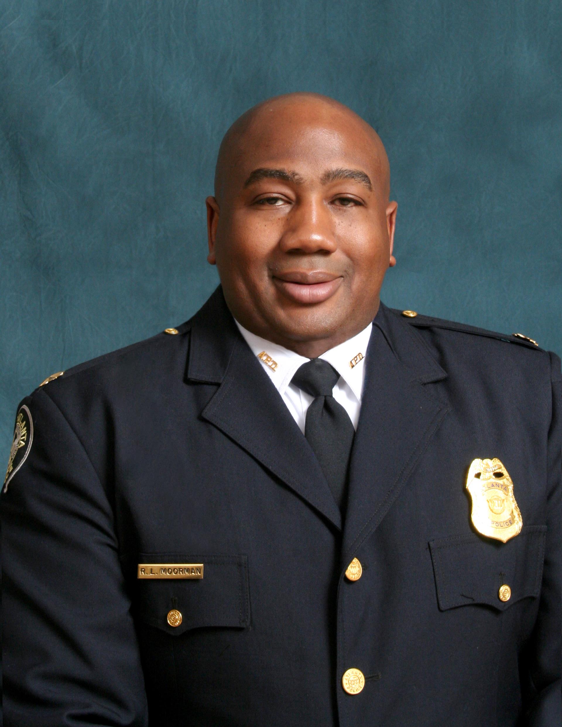 Official photo of Reginald Moorman in his dress uniform. He is a 30-40something black male, with a closed lip smile.