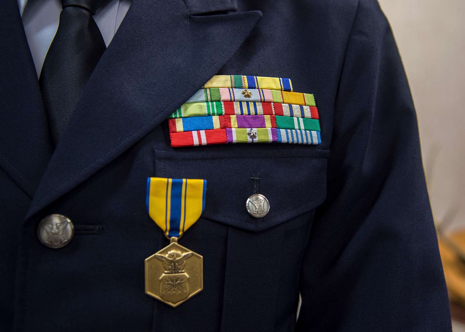 The left breast of a male airman commander, displaying his ribbons and Air Force Commendation medal.