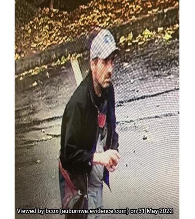 A white male in a white hat and black jacket holding rocks