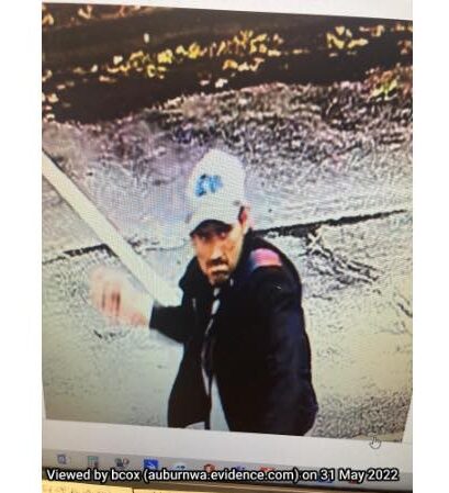 A white male in a white hat and black jacket mid-throw