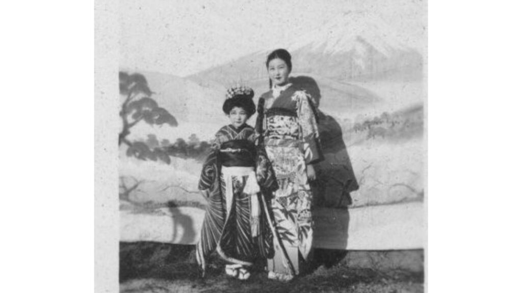 A black and white photo of a woman and child in traditional Japanese formal attire.