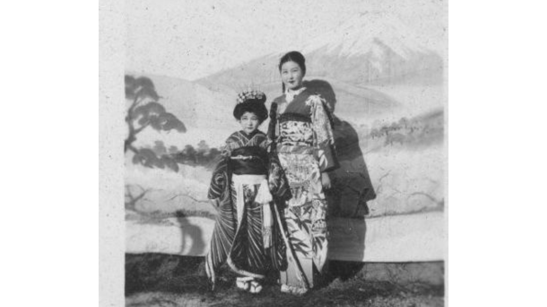 A black and white photo of a woman and child in traditional Japanese formal attire.