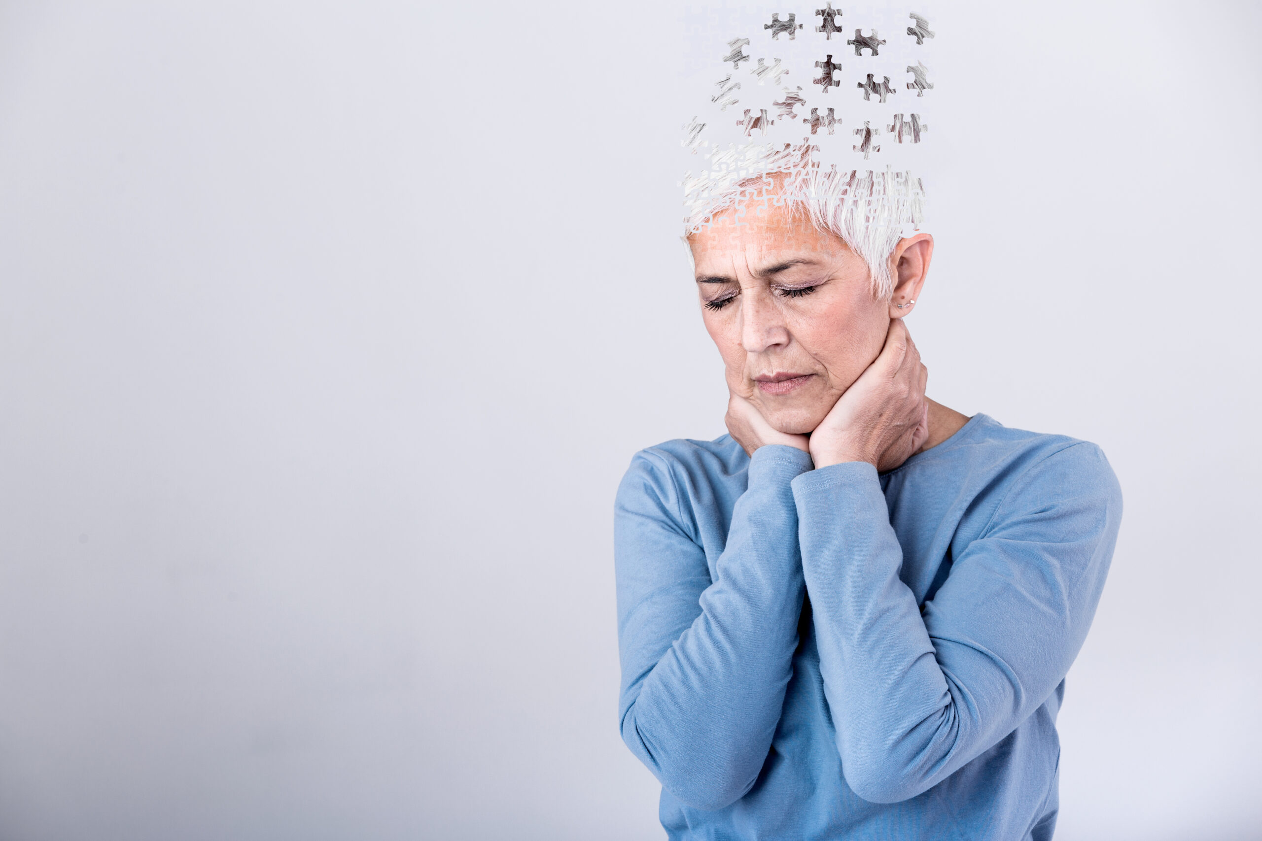 Senior woman losing parts of head as symbol of decreased mind function. Senior woman losing parts of head feeling confused as symbol of decreased mind function.
