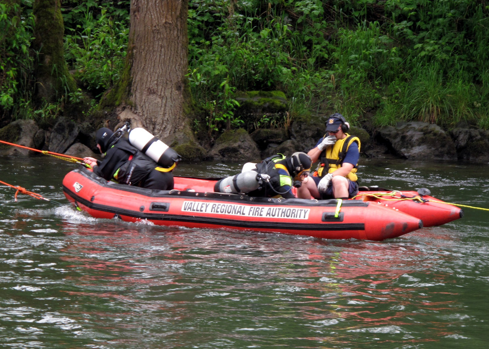 Fire rescue divers on a rescue boat in the river