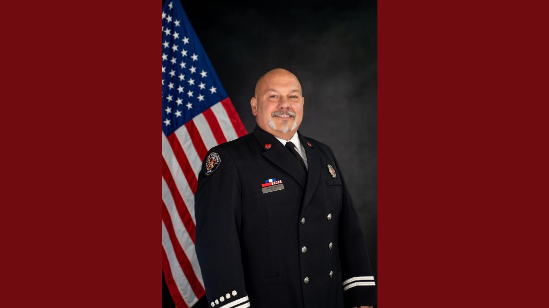 VRFA Captian Jon Hillebrant, an older white male with a mustache, smiles in an official photo while in dress uniform